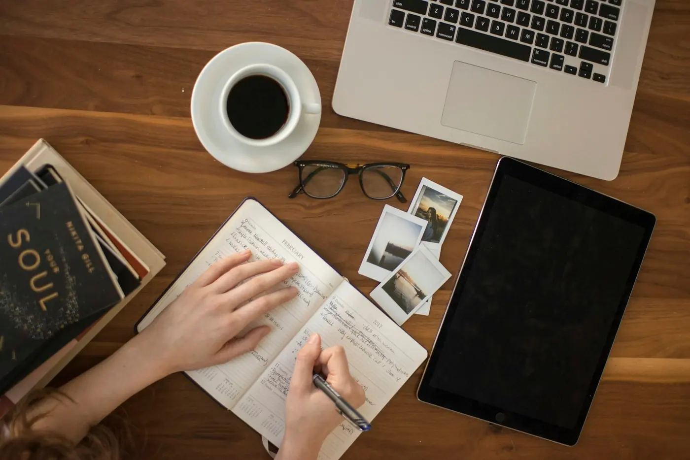 Student taking notes with a tablet and laptop